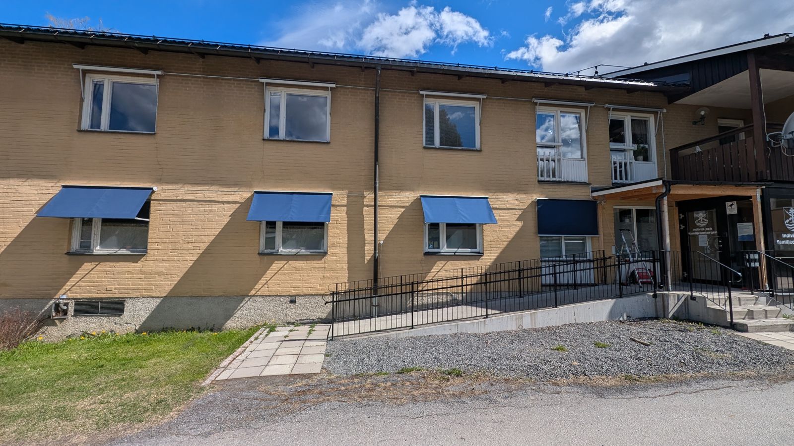 Flera mörka fönstermarkiser i rad på en fastighetsfasad