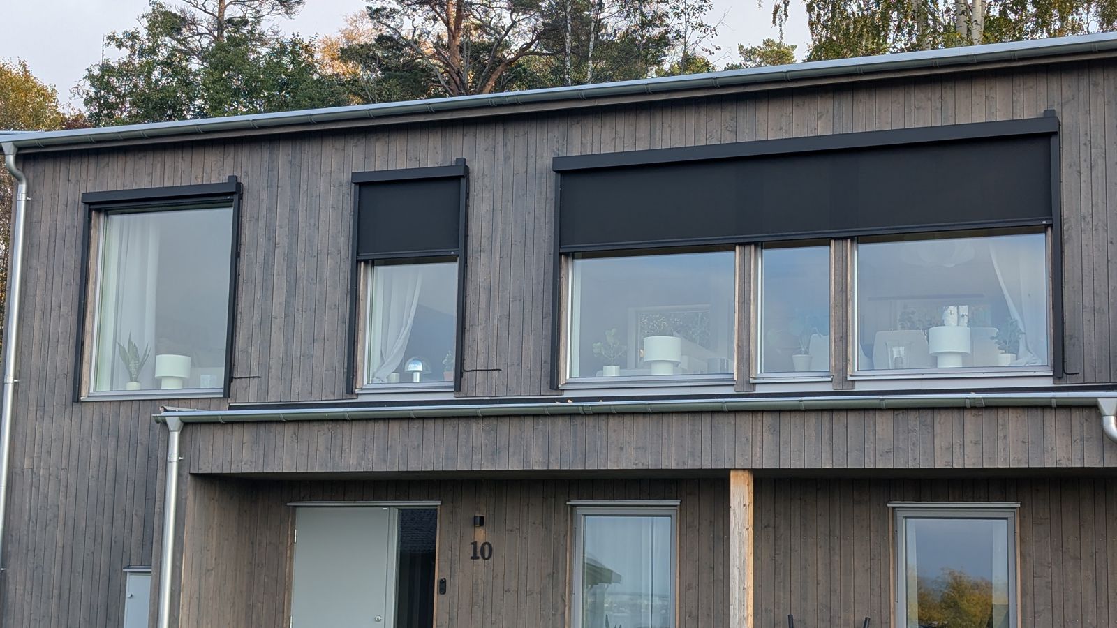 Zip screens i olika bredder på en grå träfasad