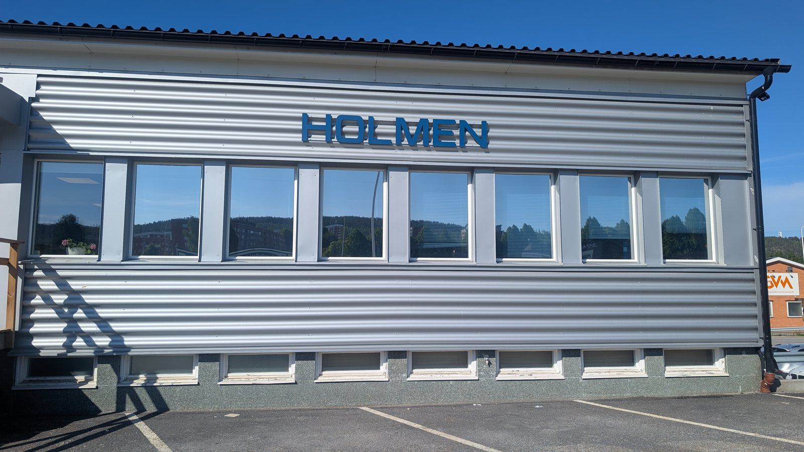 Fönsterrad med solfilm på en byggnad med plåtfasad