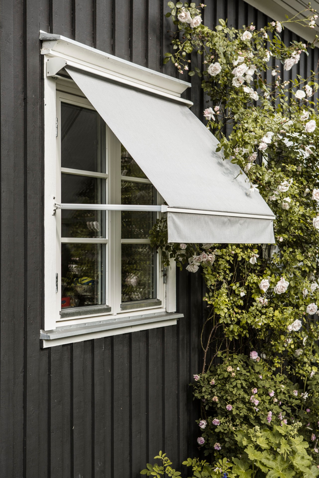 Fönstermarkis på svart villafasad